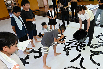 「順番に歌詞を書いていく児童たち」の画像