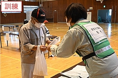 「安定ヨウ素剤（模擬）の配布を受ける住民」の画像